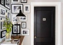 Small entryway features a black and white photo wall on the wall bringing life to a small foyer space. White trim around a black water closet door adds a contrasting finish near the small entry space.