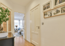 A hallway wall with pictures hung.