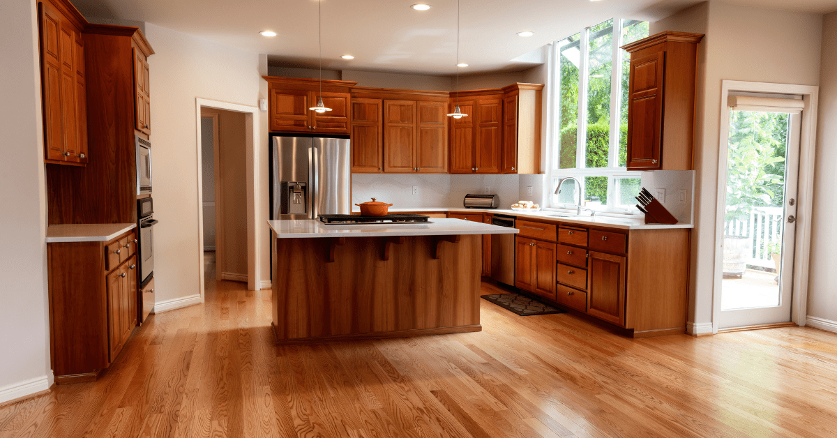 A modern kitchen with island and built-in stove.