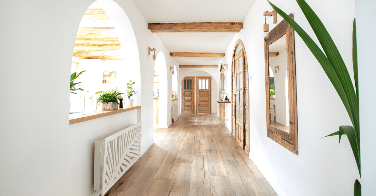 A bright white hallway with mirror on the wall.