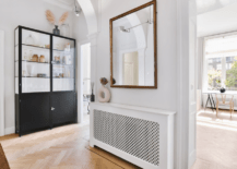 A unique hallway with mirror and other wall decor.