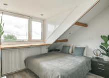 A small boys bedroom with floating desk mounted onto the wall.