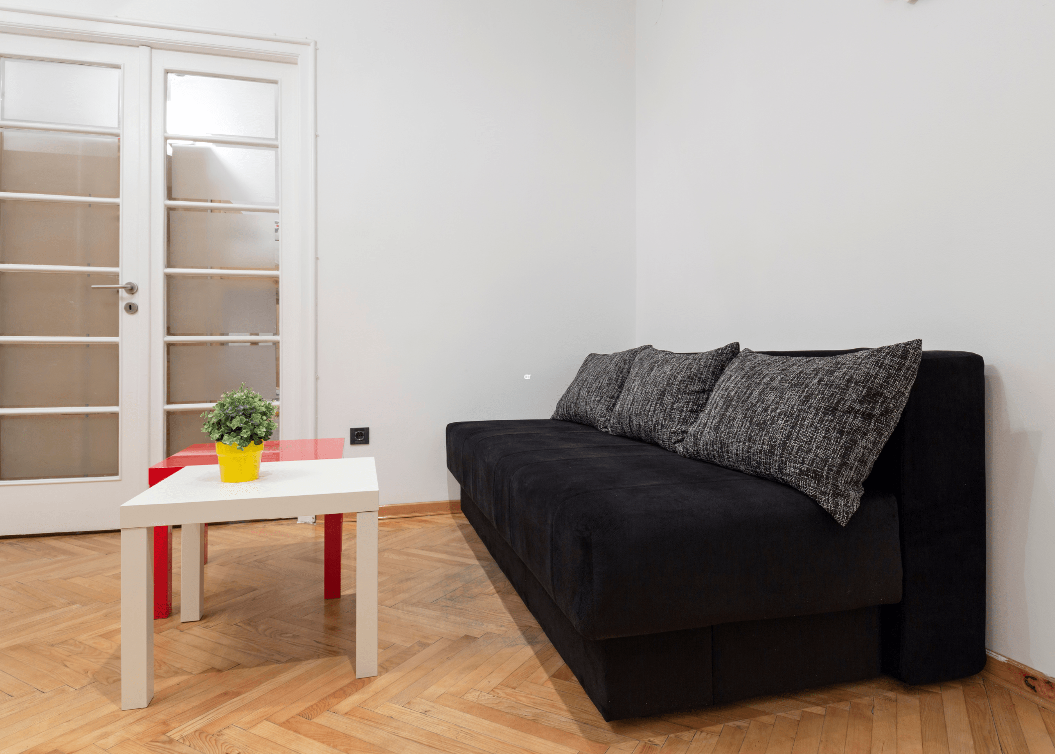 open minimalist living room with black couch and ikea coffee tables