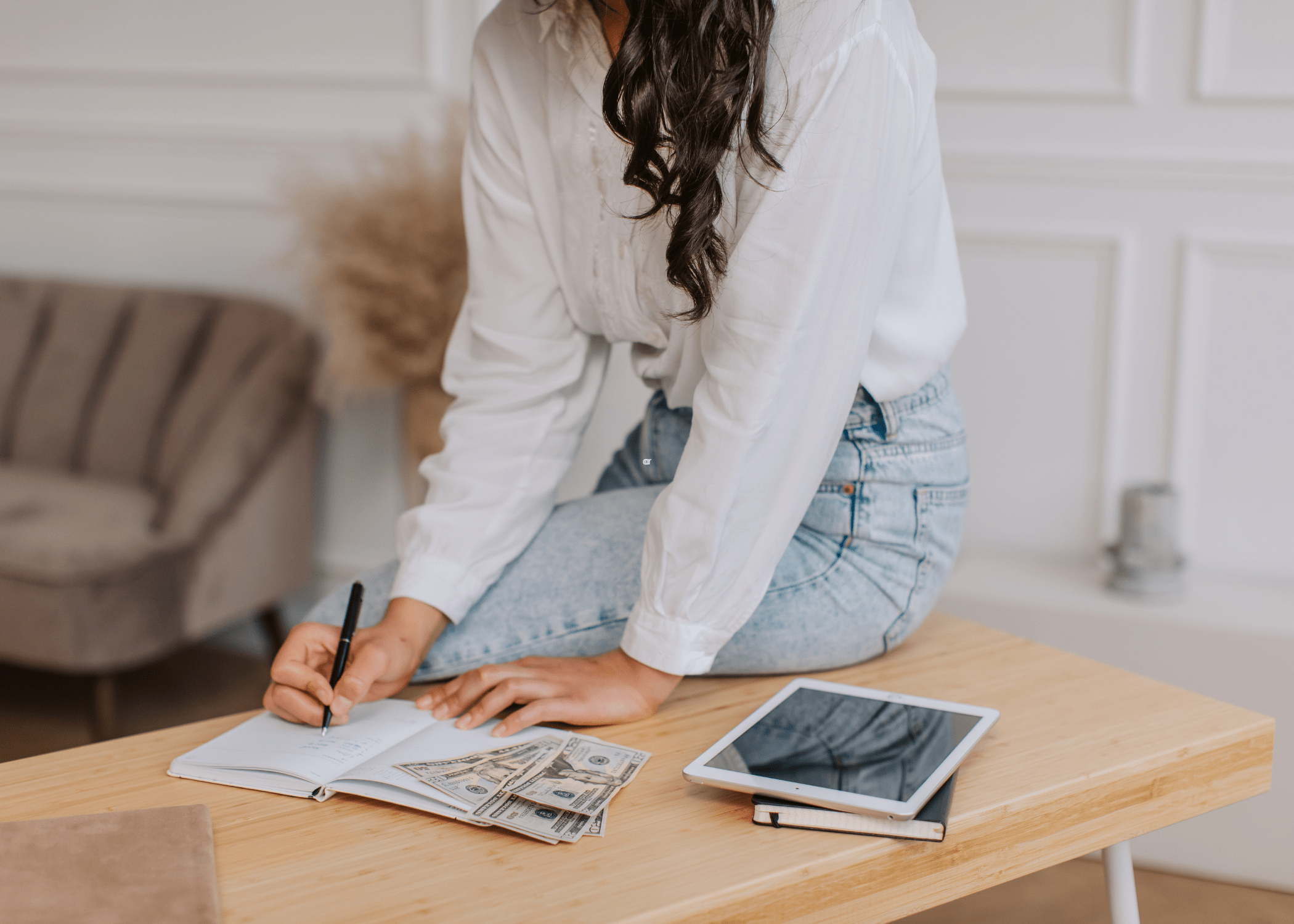 woman with iPad and notebook setting a budget