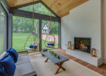 small sunroom with brick fireplace and hanging chairs